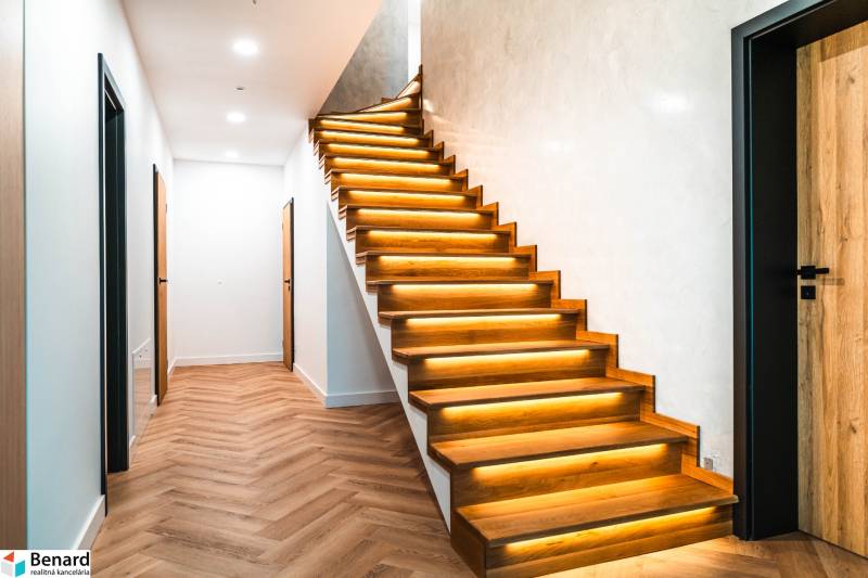 A hallway with a staircase and a wooden decor floor in a family house.