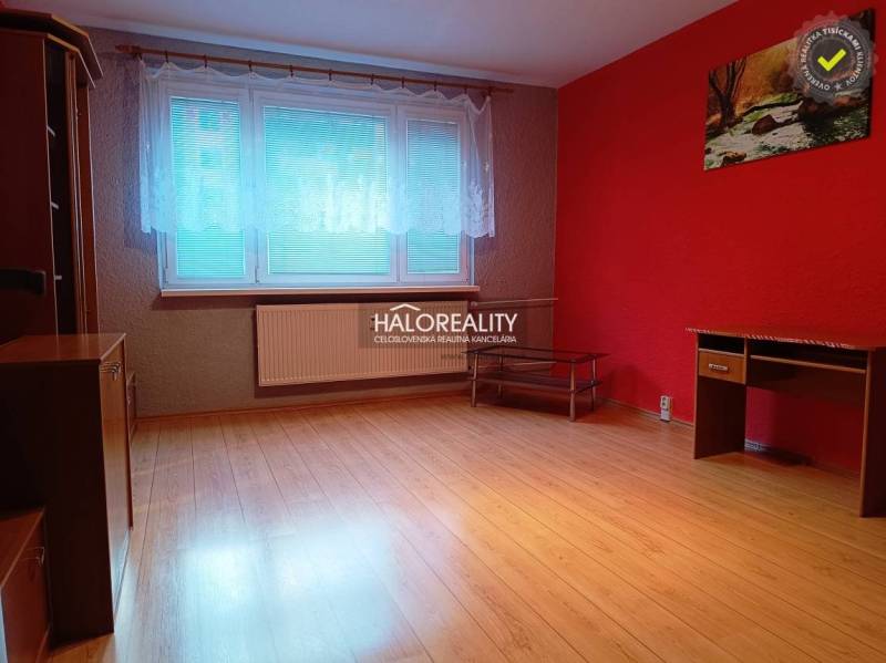 Interior of a 3-room apartment with a red wall and a floor with a wood decor.
