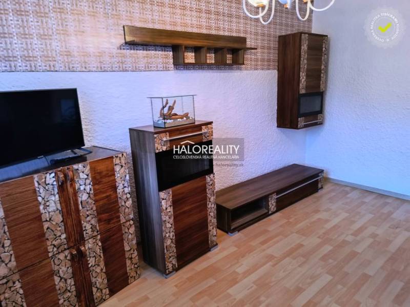 Living room in a 3-room apartment with a television and a wooden decor floor.