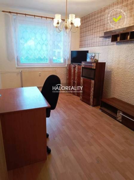 A room with a wooden decor floor, an office desk, and shelves in a 3-room apartment.