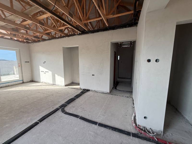 Interior of a family house with unfinished walls and a wooden decor floor.