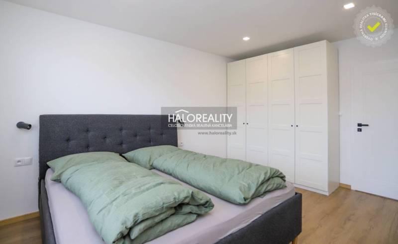 Bedroom with a double bed, built-in wardrobes, and a wooden decor floor in a 2-room apartment.