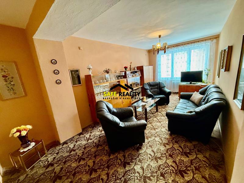 Living room in a two-room apartment with a sofa set and a glass display cabinet.
