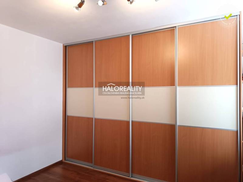 There is a built-in wardrobe with wooden sliding doors in the studio apartment.