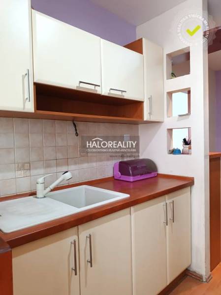 Kitchen corner in a studio apartment with a sink and cabinets.