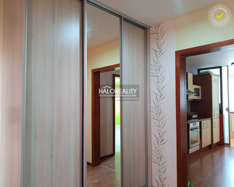 Studio apartment with a kitchen, wooden paneling, and a built-in wardrobe.