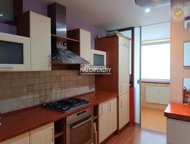 A studio apartment kitchen with a gas stove and glass cabinets.