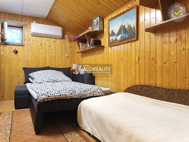 A room in a cabin with wooden wall paneling and a comfortable bed.