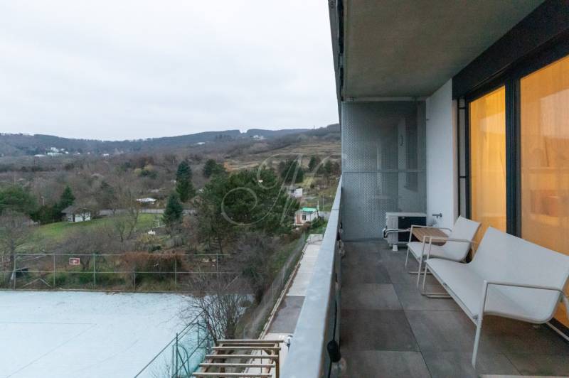 A balcony in a one-room apartment, view of nature, overlooking gardens and trees.