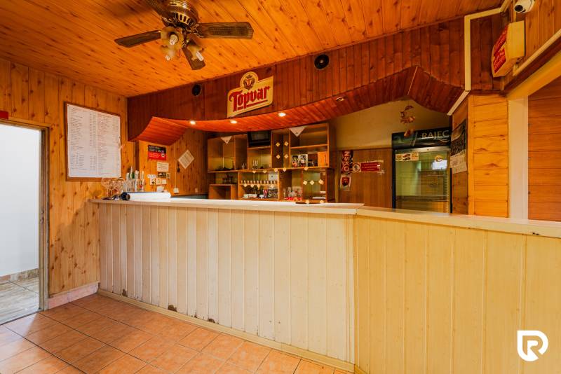 The interior of a family house with a booth and wooden paneling at the bar.