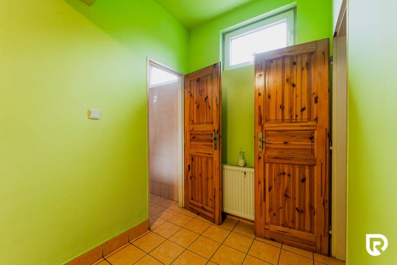 Green walls, wooden doors, and tiled floor in a family house.