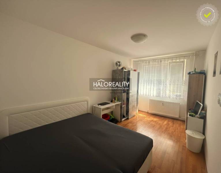 Bedroom in a 3-room apartment with a bed, wooden decor flooring, and storage spaces.