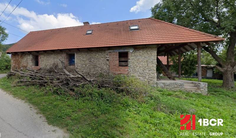 A cottage in Zliechov with stone walls and a sloping red roof.