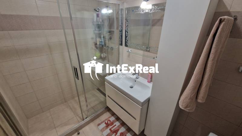 A bathroom with tiles and a shower in a 3-room apartment.