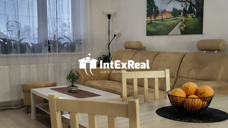 A comfortable sofa in a 3-room apartment with a wooden decor floor and decorative elements.