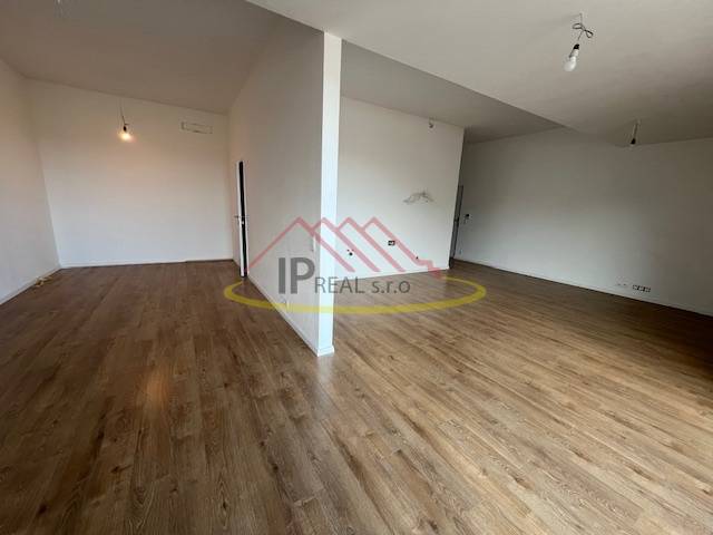 A room in a 2-room apartment with a floor featuring a wooden decor and white walls.