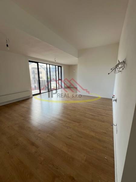 Interior of a 2-room apartment with a wooden decor floor and large windows.