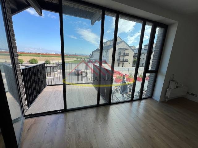 Interior of a 2-room apartment with large windows and a floor with a wooden decor.