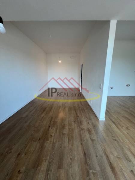 2-room apartment with wood-patterned flooring and white walls.