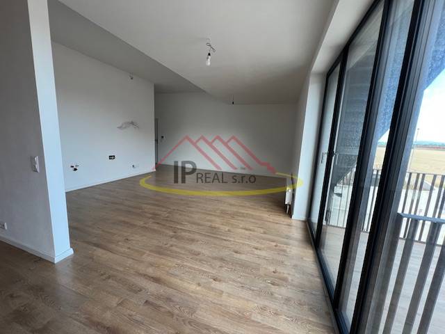 Spacious living room in a 2-room apartment with a balcony, floor with wood decor.