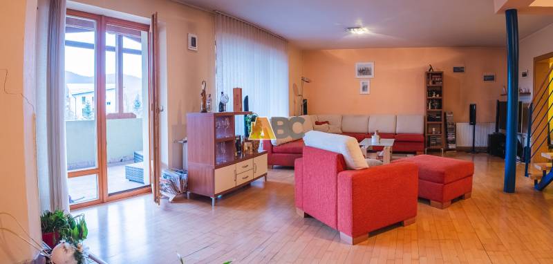 Living room in a villa with a red sofa and a wooden-patterned floor.