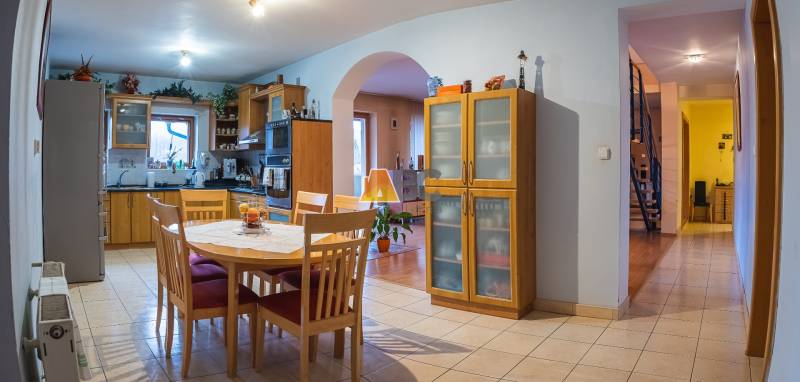 A kitchen in a villa with wooden decor, a dining table, and built-in cabinets.