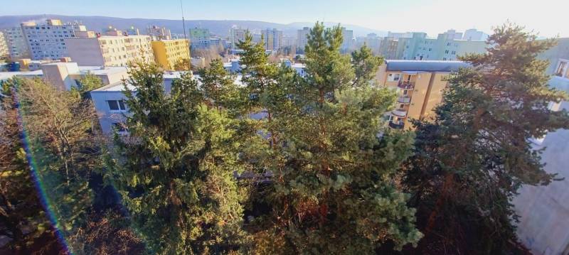 A tower with apartment blocks and trees in Bratislava - Dúbravka on Tranovského, near 3-room apartments.
