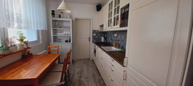 Kitchen in a 3-room apartment with a wooden table, cabinet, and plants.