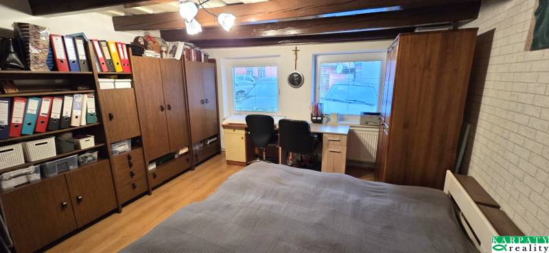 A room in a family house with wooden decor, a desk, and storage cabinets.
