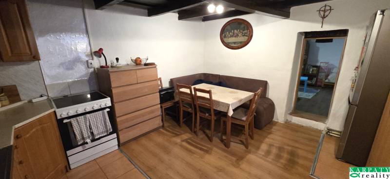 A kitchen in a family house with a corner sofa and a wooden decor floor.