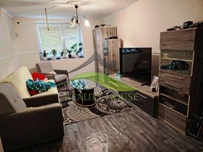 Living room in a family house with sofas and a TV, floor with wooden decor.
