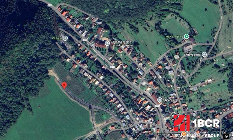Aerial map of development plots in Snežnica, surrounded by greenery and adjacent buildings.