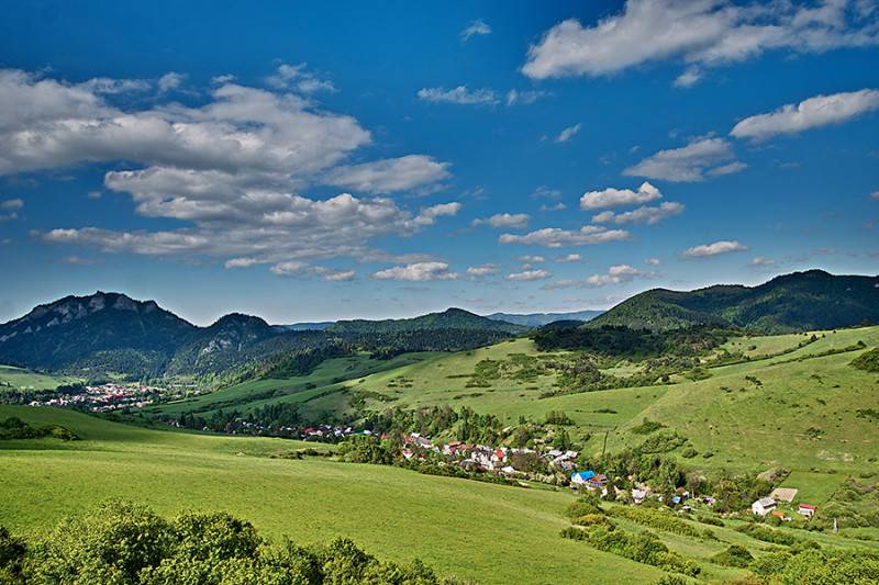 Beautiful landscape around Lechnice with agricultural and forest lands under the blue sky.