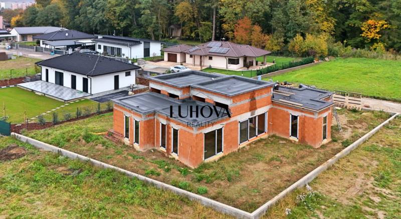 A family house on Medová Street in Lednické Rovne, surrounded by green gardens and a forest.