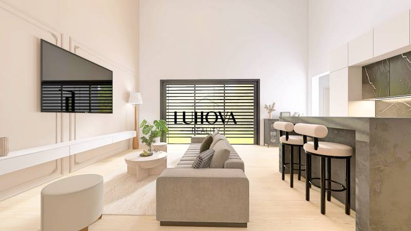Living room in a family house with a wooden decor floor, a sofa, and a television on the wall.