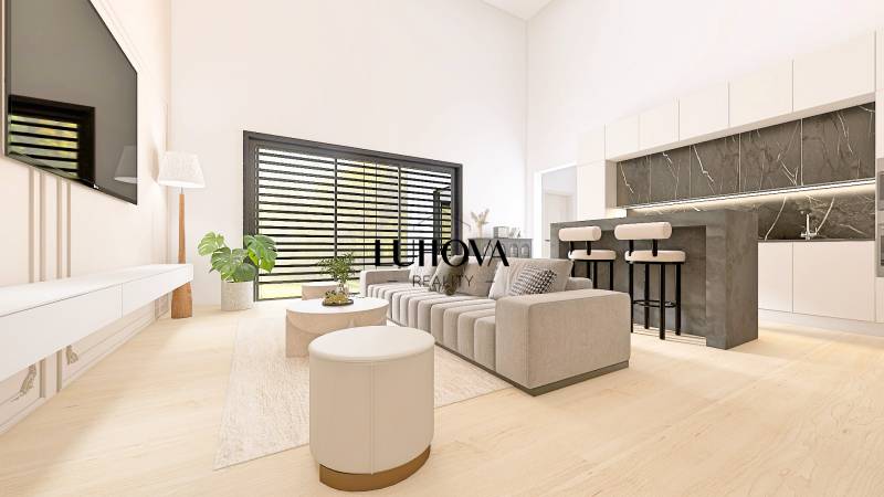 Living room in a family house with a sofa, television, bar counter, and wooden decor flooring.