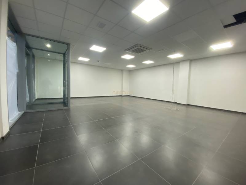 Commercial premises with a dark floor and a glass partition.