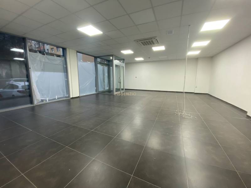 Commercial spaces with dark tiles, white walls, and glass displays.