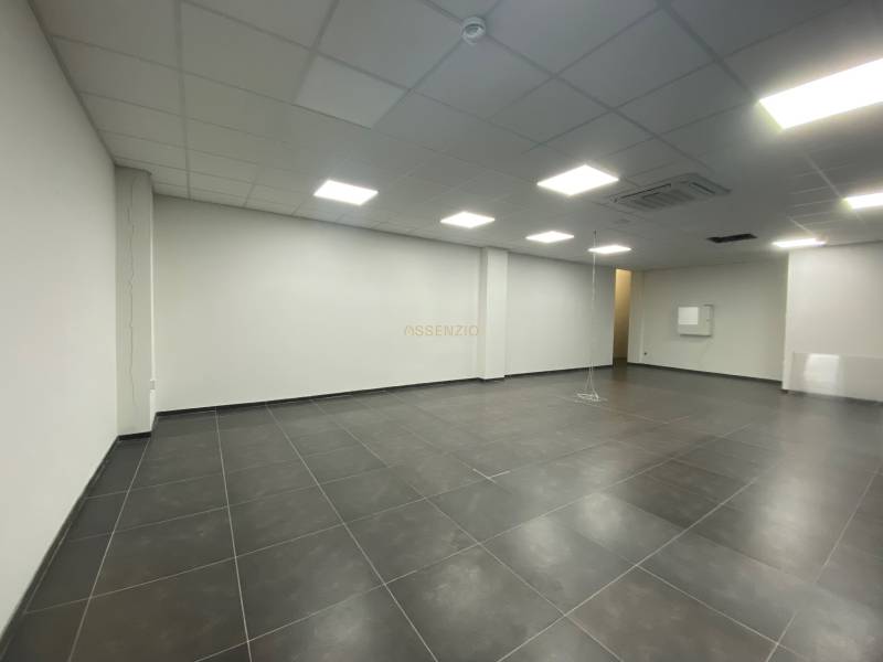 Spacious commercial spaces with tiled floors and suspended ceilings.