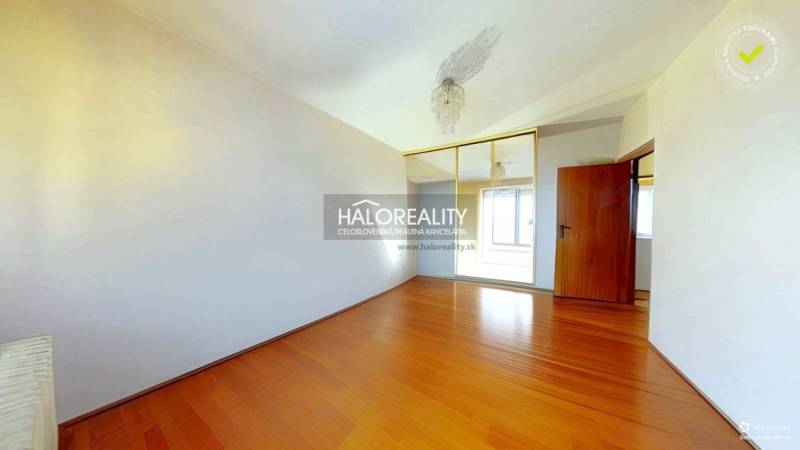 A room in a 3-room apartment with a wood-patterned floor and a built-in wardrobe.