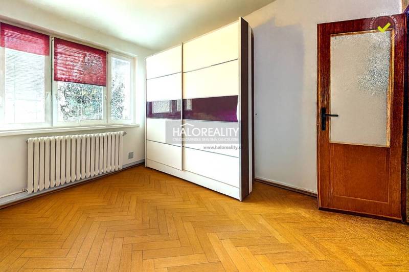 A room in a 3-room apartment with a wooden decor floor and a wardrobe.