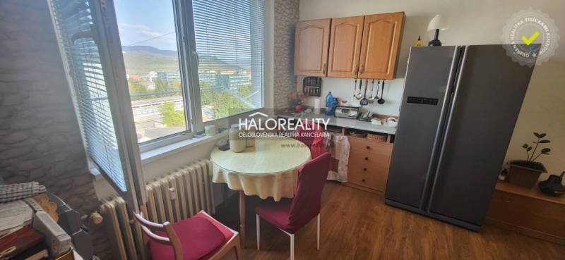 Kitchen in a studio apartment with a table, chairs, and a view from the window.
