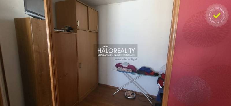 Wardrobe in a one-room apartment with wooden decor, storage cabinets, ironing board.