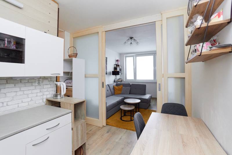 2-bedroom apartment with a kitchen and living area, wooden decor flooring.