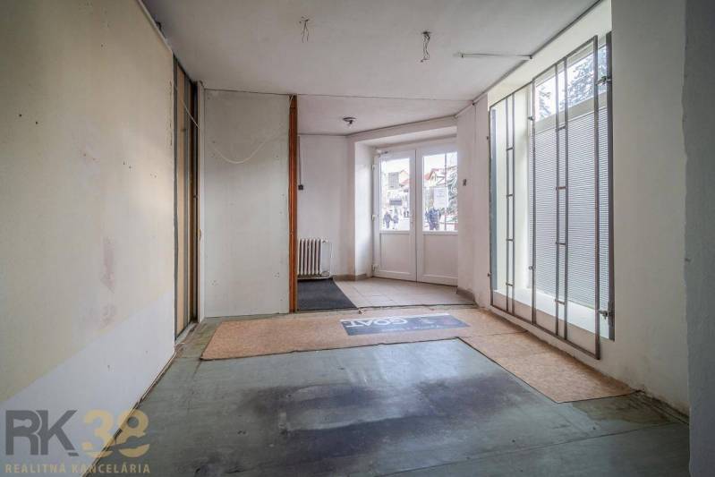 Interior of a building with glass doors and frosted blinds, carpeted floor.