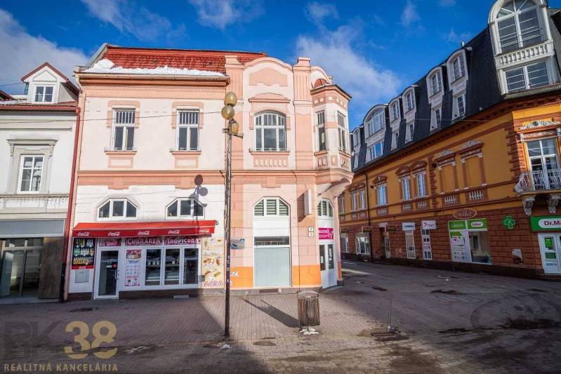 A historic building in Poprad surrounded by shops on the square.