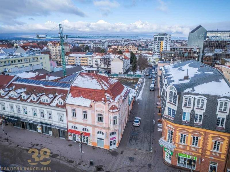 A view of snow-covered buildings in Poprad with the panorama of the Tatras in the background.