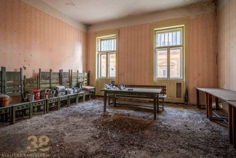 A worn-out room with benches and mess in an old building.