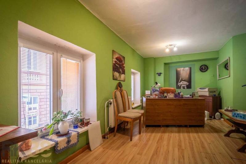 Office with wooden floor decor, green walls, desk, and decorations.