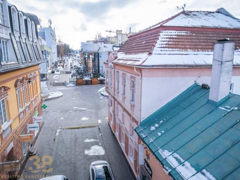 Winter street in Poprad, buildings with historical architecture, snow on the roofs and pavement.